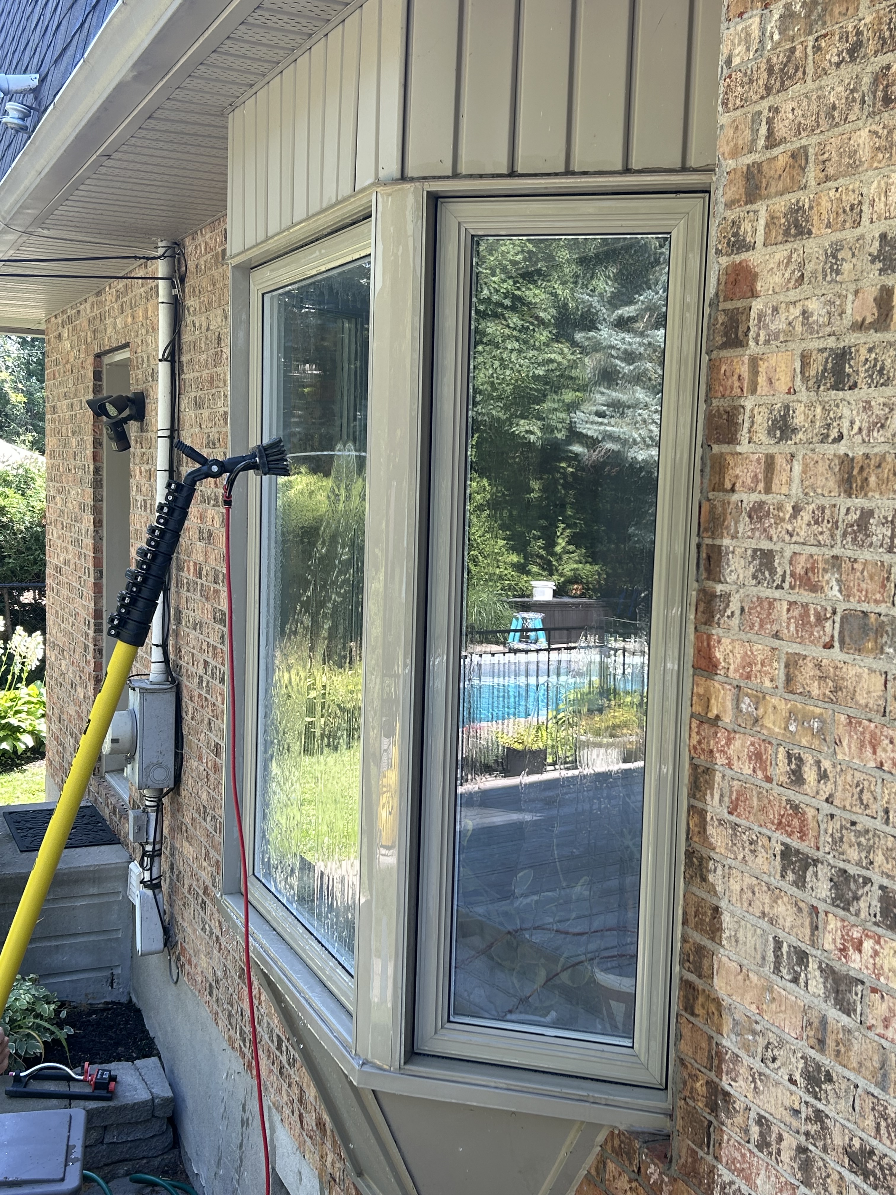An immaculate storefront window with delicate frosting and a refined etched logo, finished to a mirror-smooth surface with graceful, understated transparency. The window is set within a chic commercial streetscape, with minimalist signage and muted silver-grey marble tiling around the entrance. Morning diffused daylight washes across the glass, producing subtle gradients and faint reflections of the subdued street scene beyond. Shot at a low angle with a slight tilt, the vignette focuses attention on the flawless window finish and harmonious architectural lines. The mood is upscale and inviting, blending minimalist elegance with photographic realism to highlight Vitres Reflexio’s premier commercial cleaning services.